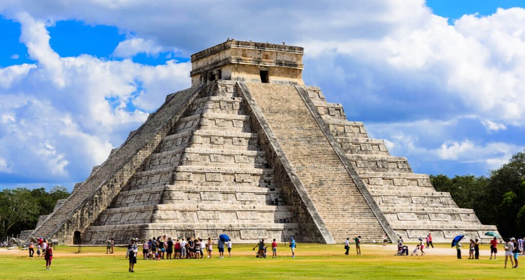 Pirámide antigua con turistas alrededor